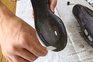 ヘラを使って、両面に接着剤を塗布する。靴用接着剤でく靴底のはがれを補修。
